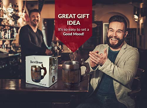 Man smiling with a barrel mug in a cozy bar setting.