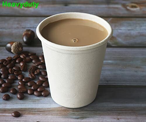 Paper cup filled with coffee and coffee beans on wooden table