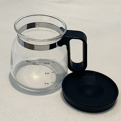 Glass coffee carafe with black handle and lid.