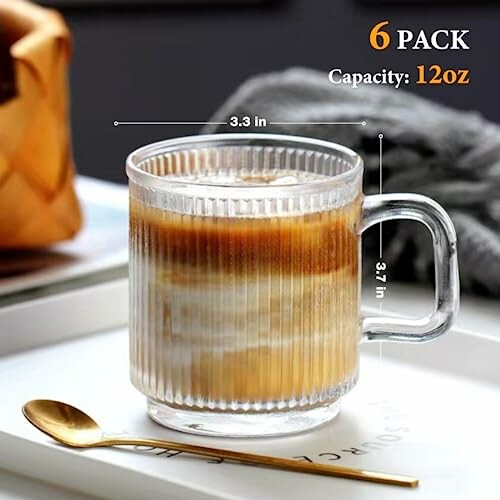 Clear glass coffee mug with measuring dimensions and gold spoon