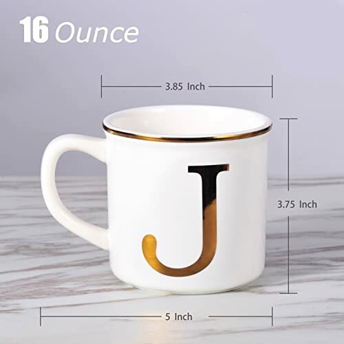 White mug with letter J and gold trim on marble surface