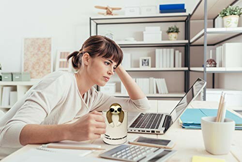 Woman working at desk with a laptop and a novelty mug.